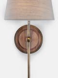 Circular wall light backplate made from solid walnut with a sand cast brass casing and linen shade.