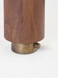 Details of the table light's walnut body and textured brass base with thumb turn switch.