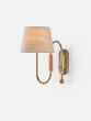 Curved wall light made from brass tubing and walnut accents with a thumb-turn switch and linen shade.