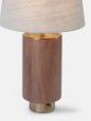 Table light with a walnut body, textured brass base, thumb turn switch, and linen shade.